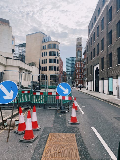 A view of a city street in Holborn with a designated loading bay area marked with red lines and signs, situated directly in front of a modern multi-storey building with large windows and clean archite